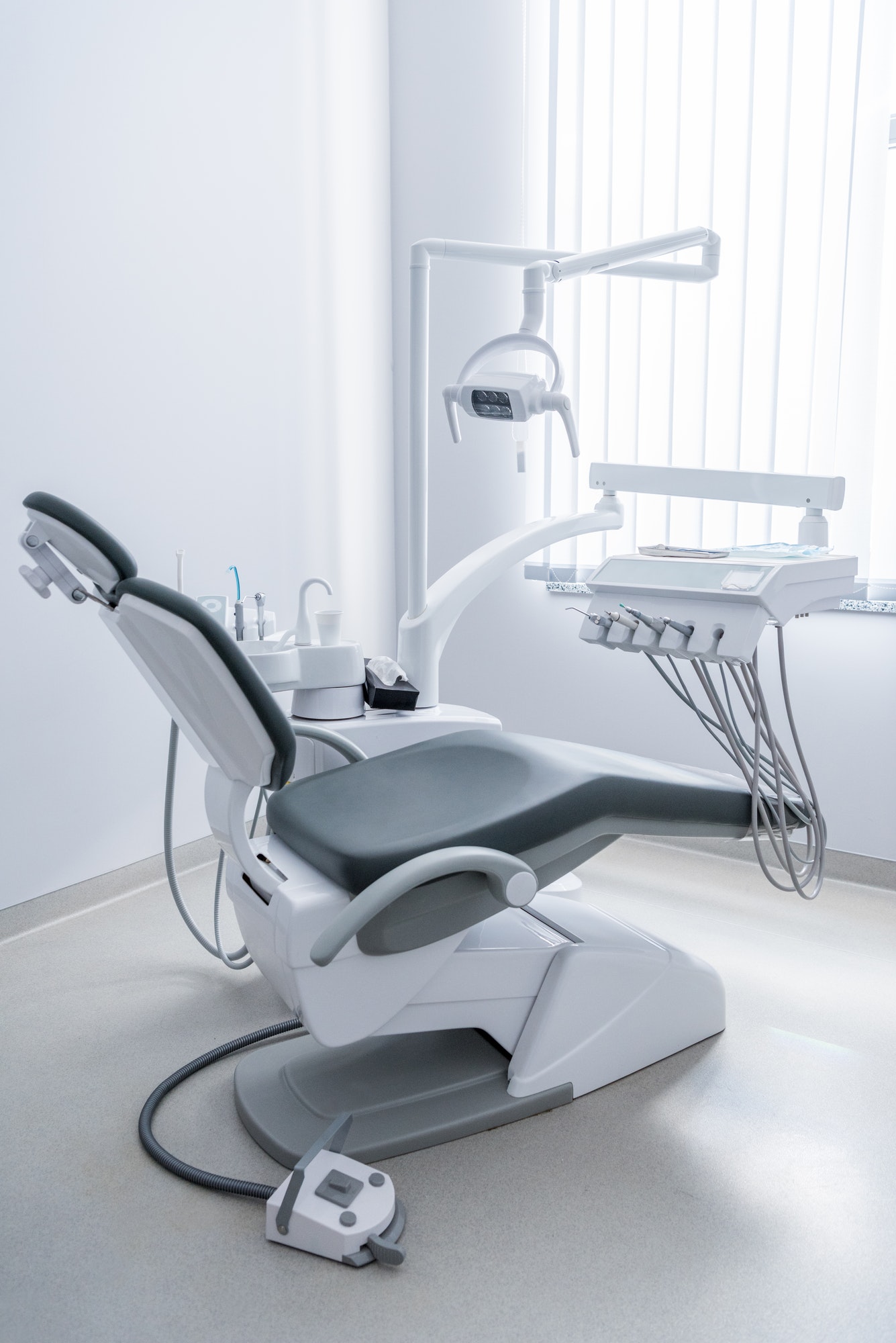 empty dentist office with chair and various dental equipment 1